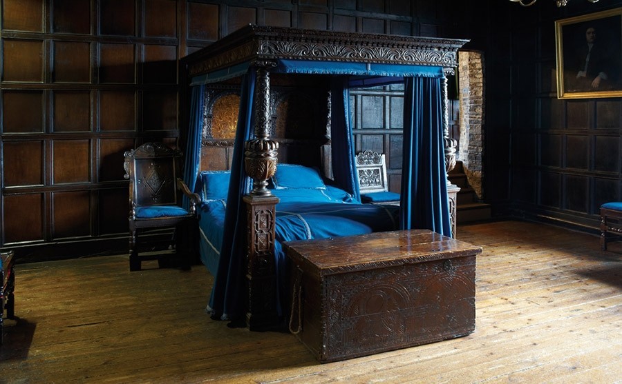 Four Poster bed in a grand bedroom with a brown cabinet infront.