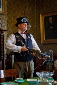 Man in steampunk outfit holding a crowsbow