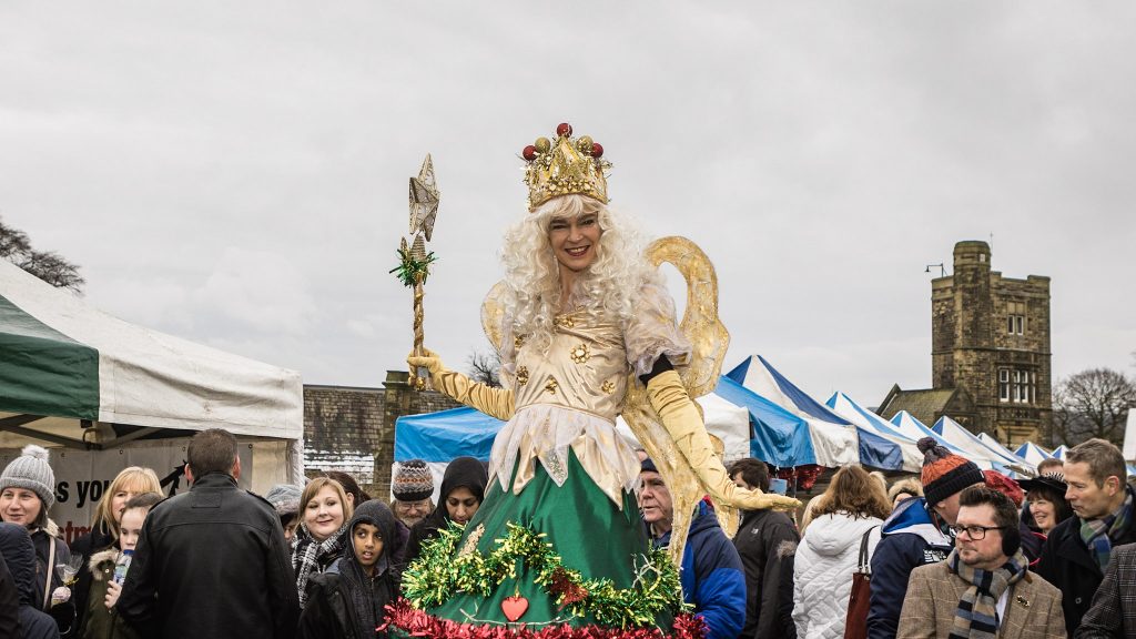 Stilt walkers dress as the fairies on top of Christmas Trees