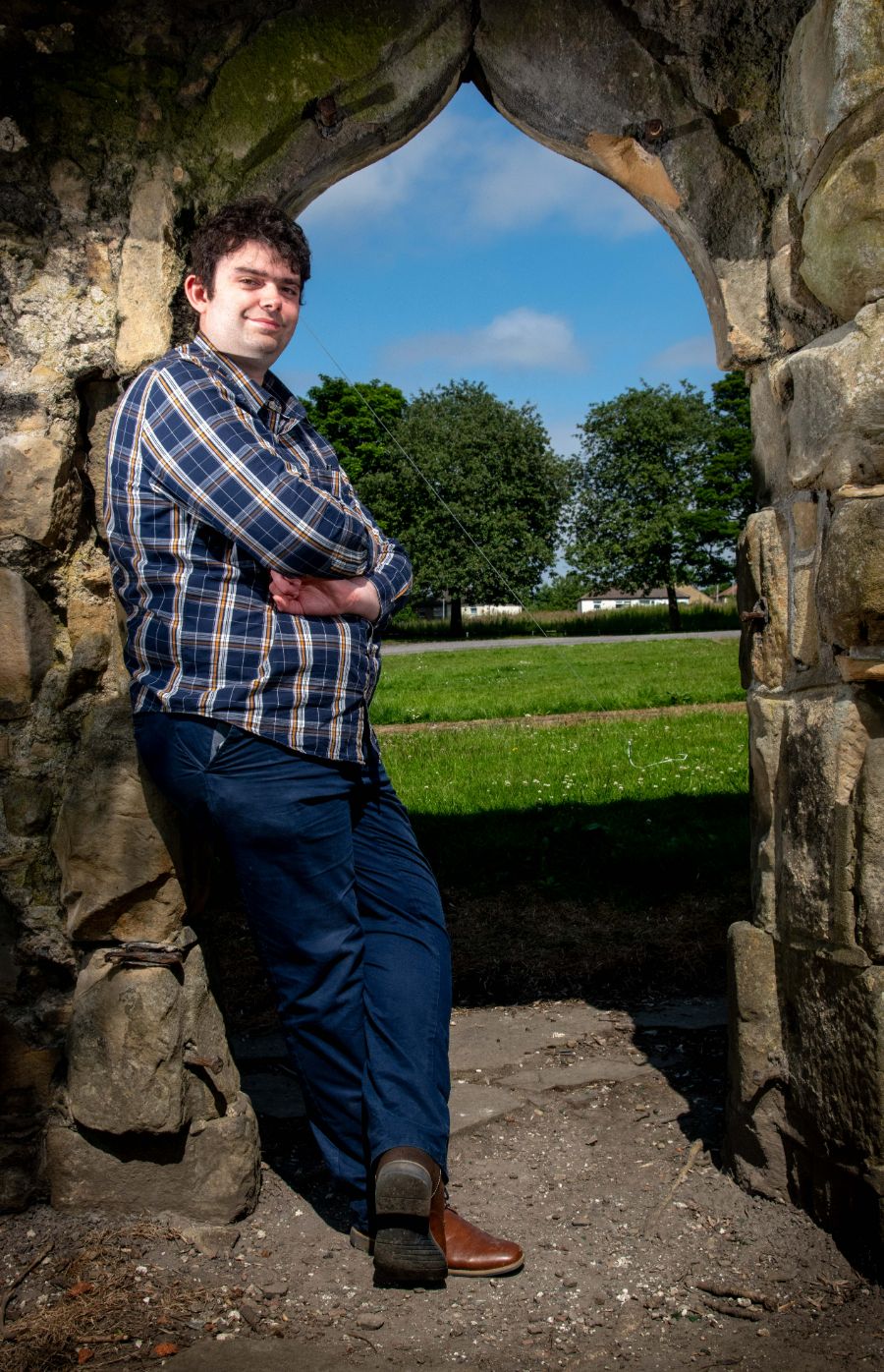 Daniel standing by the medieval wall in the grounds of Bolling Hall
