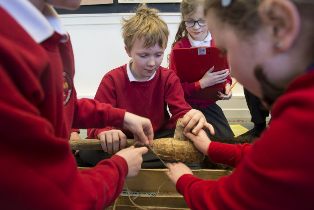 Stone Age workshop at Cliffe Castle Shows school children taking part in a mock dig.