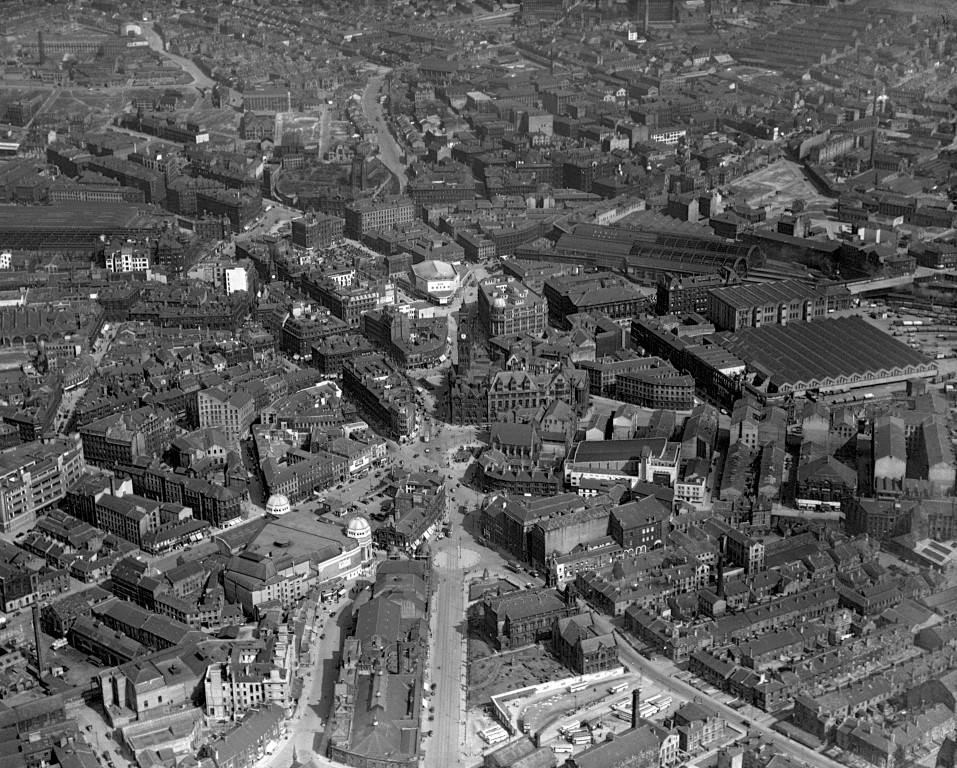 A black and white aerial view of Bradford City Centre taken in April 1947. If you follow the straight road from the bottom centre upwards, it takes you to Bradford City Hall. To the left-hand side of that road is the Alhambra and old Odeon buildings, both with domed turrets. Photographer: C H Wood. In Bradford District Museums and Galleries collection (5081). 