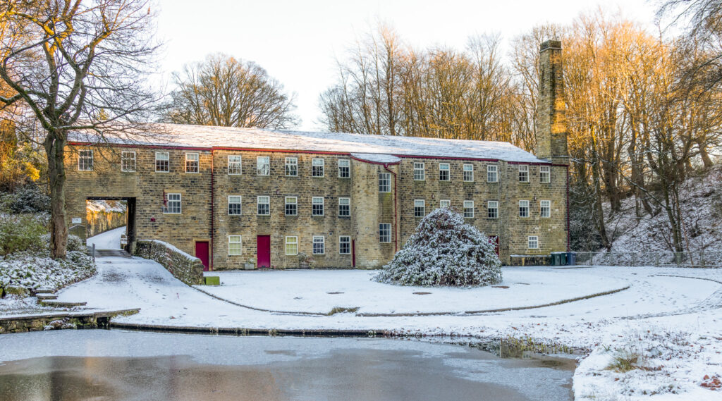 Mill building in the snow,  with a frozen mill pond in front