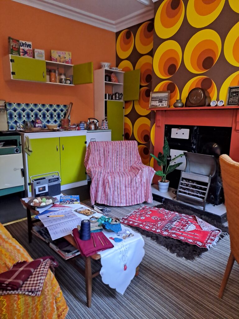 View of kitchen aria, with a chair and the electric fire also in view