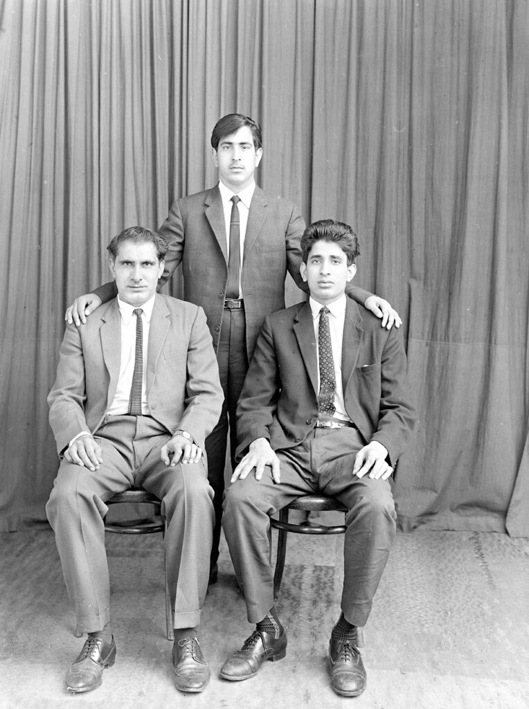 B&W image of 3 Pakistani men, from Belle Vue Archive.  (Ages suggest might be father and two sons?)