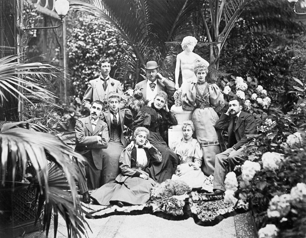 B&W photo of a group of men and women in typical later victorian outfits, surrounded by exotic planting - Henry Isaac Butterfield is recognisable at the back