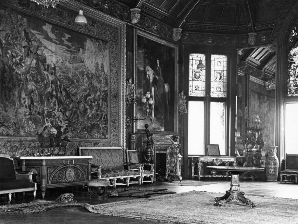 B&W of another section of the ballroom, with images representing. music and the arts visible in the stained glass. Also visible is a large portrait of Empress Eugeni