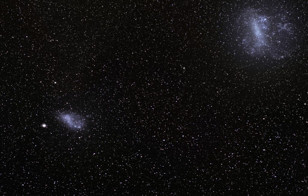 image of the night sky showing megellan clouds (bright groupings of mini-galaxies)