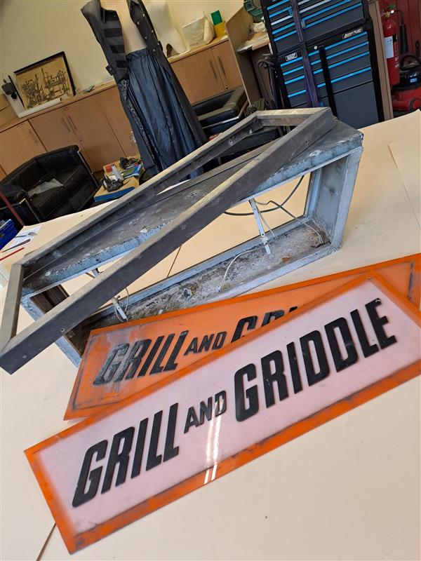an exterior signs being cleaned so it is ready for display. Dust, dirts and grease is visible on the sign
