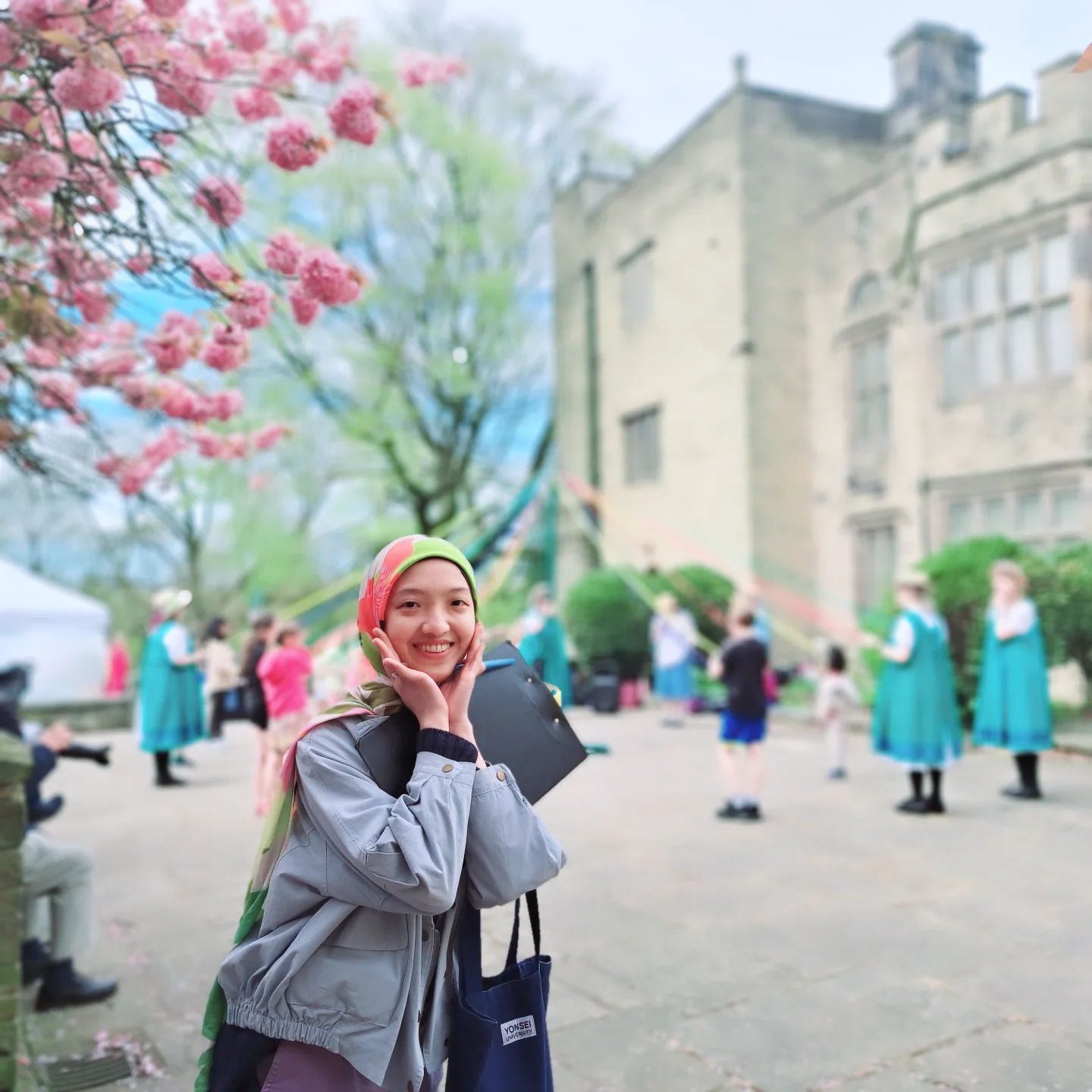 an event happening outside Bolling Hall - there are dancers in the background and a woman is smiling directly at the camera