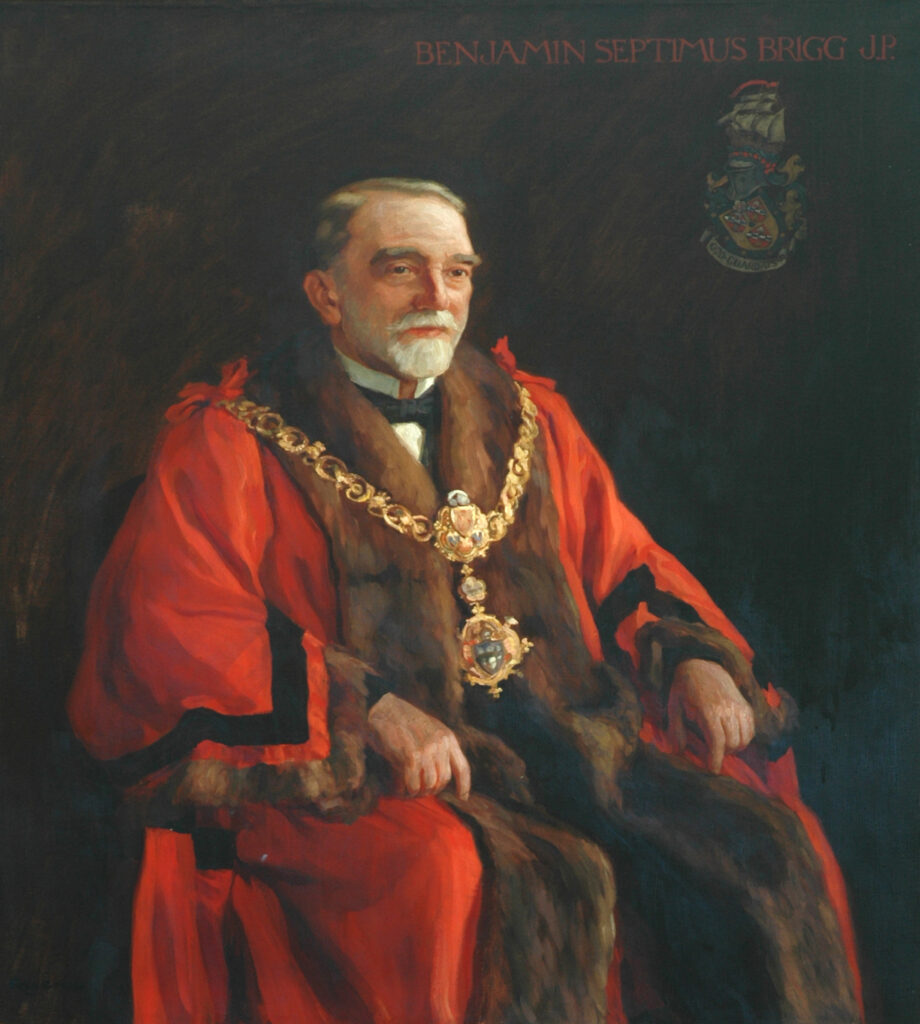 white man with short greying hair, short white beard and mustache.  He is dressed in formal black tie, wearing red Mayoral Robes over the suit and with the Keighley Mayoral Chains
