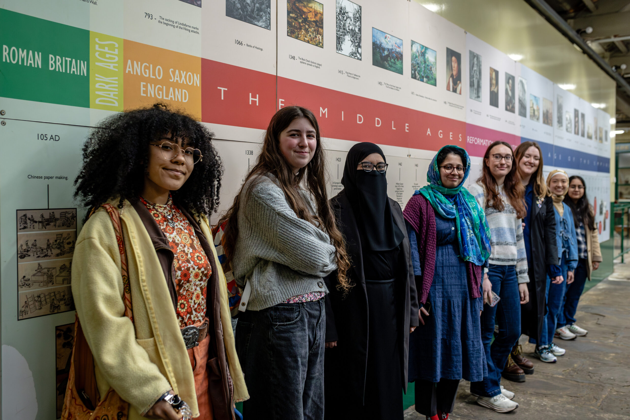 A group of young people stood in front of a timeline