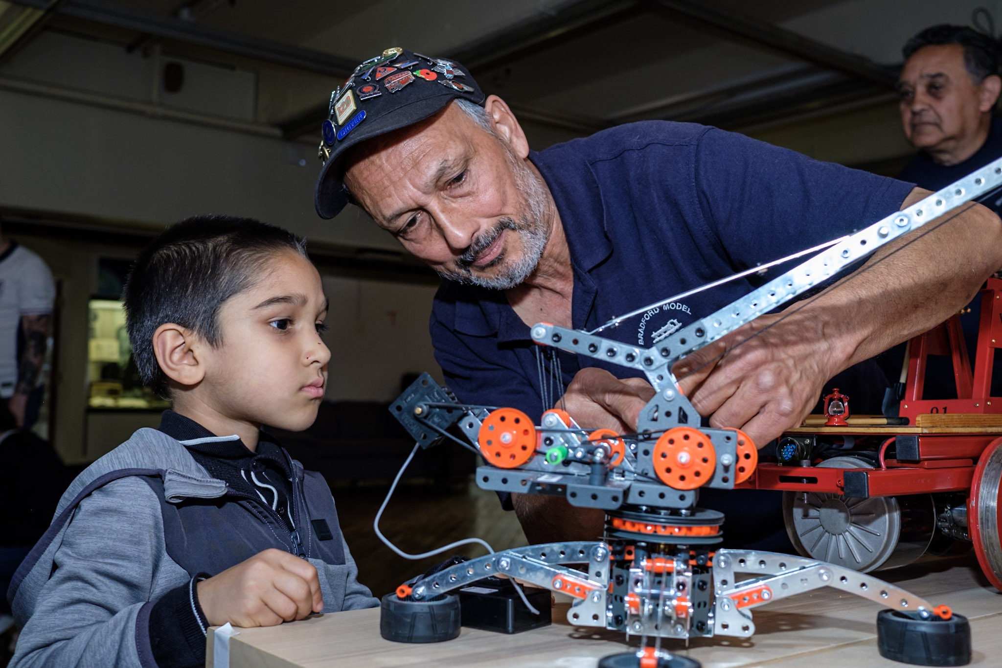 adult and child looking closely at a working minature model of a crane.